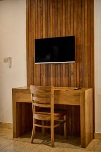 a wooden desk with a television on a wall at Abangan Bungalow in Ubud
