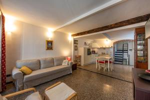 Una sala de estar con un sofá y una cocina. en Acquario a 5 min - Jacuzzi e vista sui vicoli, en Génova