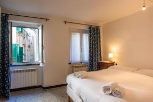 Un dormitorio con dos camas y una ventana. en Acquario a 5 min - Jacuzzi e vista sui vicoli, en Génova
