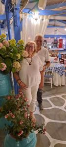 a man and a woman standing next to flowers at Malia Star Apartments in Malia