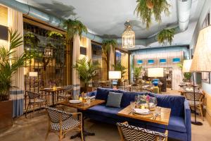 a restaurant with a blue couch and tables and chairs at Pamplona Catedral Hotel in Pamplona