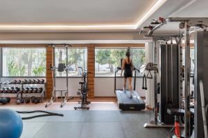 a woman walking on a treadmill in a gym at Blazer Suites Hotel in Athens
