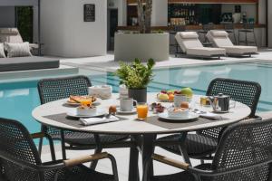 a table with food on it next to a swimming pool at Blazer Suites Hotel in Athens