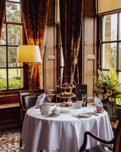 a dining room with a table with a plate of food at Crathorne Hall in Yarm +42 photos