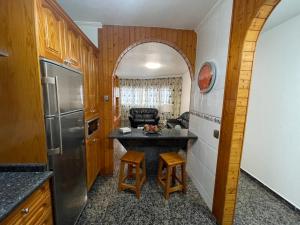 a kitchen with a refrigerator and a table in a room at Vivienda Vacacional C & M in Puerto del Rosario