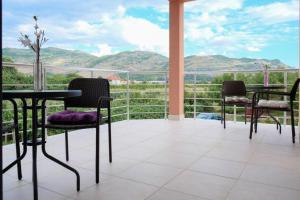 a balcony with tables and chairs and a view of mountains at Apartment Trebinje in Trebinje