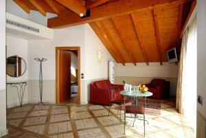 een woonkamer met een rode bank en een tafel bij Hotel La Bussola in Orta San Giulio