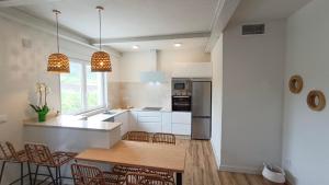 a kitchen with white cabinets and a table and chairs at O Retiro da Costa Galitrips in Muxia