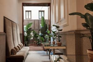 a hallway with a couch and a bunch of plants at Hospes Puerta de Alcalá, a Member of Design Hotels in Madrid