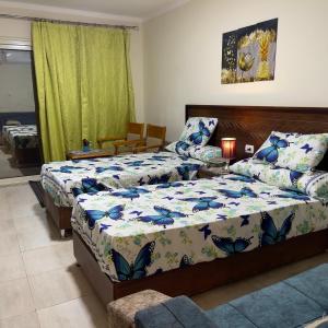 une chambre avec deux lits et un canapé dans l'établissement قريه اكوا فيو الساحل الشمالى-Aqua View North Coast, à El Qasaba esh Sharqīya