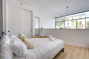 a white bedroom with a large white bed with pillows at New Luxury 2BDR unit with Sofabed in Mile End - 1D in Montréal