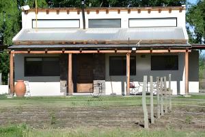 a small white house with a porch and windows at Finca Ogawa in Los Sauces