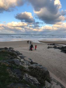 a group of people walking on the beach at Chambre bleue des Perriots in Englesqueville-la-Percée
