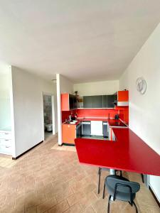 a kitchen with red cabinets and a red counter top at Apartment with swimming pool in Reno Di Leggiuno +14 photos