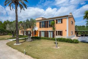 a house with palm trees in front of it at Finca Conies Romaní in Manacor