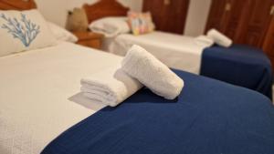 een stapel gevouwen handdoeken zittend op een bed bij Apartamento Raxobrisamar in Raxo