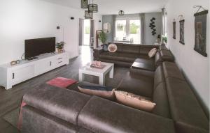 a living room with a brown couch and a tv at Pet Friendly Home In Zeewolde With Wifi in Zeewolde