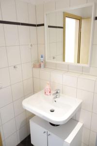 a white bathroom with a sink and a mirror at Cozy Apartment in Dresden Neustadt in Dresden