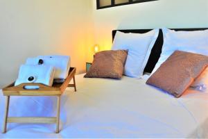 ein Bett mit zwei Kissen und ein Tisch mit einem Buch in der Unterkunft Le Central Rhône 2 - vue grandiose - in Lyon