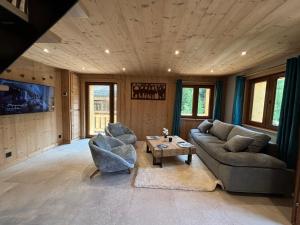a living room with a couch and two chairs and a table at Chalet l'Abériot in Montriond
