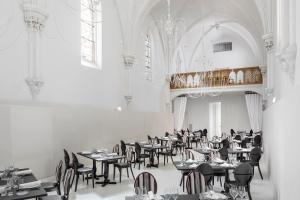a dining room with tables and chairs and a chandelier at Pamplona Catedral Hotel in Pamplona