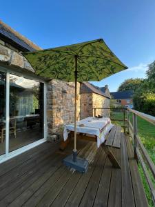 a patio with an umbrella on a deck at Le cottage in Crozon
