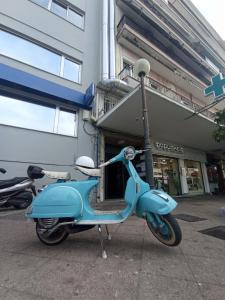 a blue scooter parked in front of a store at VespaHome in Kavála