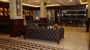 a lobby with couches and tables in a building at Hmaasat Intour Hotel فندق همسات انتور in Jazan