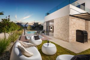 Un patio trasero con dos sofás blancos y una piscina. en Villa Abarica, en Marasi