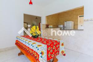 a table with a vase of flowers on top of it at Linda chacara em Mogi das Cruzes in Mogi das Cruzes