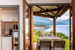 a kitchen and a table with a view of the water at L'Ecrin du Lac in Chorges