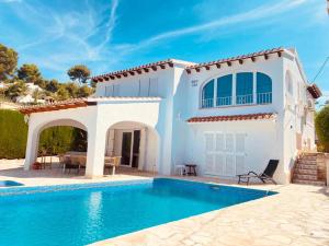 a white house with a swimming pool in front of it at Villa Besuc Benissa Moraira 8 personnes in Benissa
