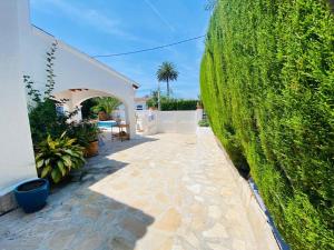 a garden with a large green hedge next to a building at Villa Besuc Benissa Moraira 8 personnes in Benissa