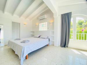 a white bedroom with a bed and a window at Villa Besuc Benissa Moraira 8 personnes in Benissa +21 photos