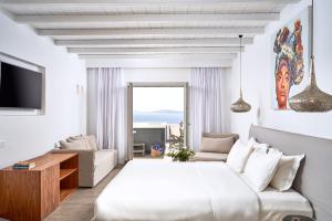 a white bedroom with a bed and a couch at Hippie Chic Hotel in Agios Ioannis Mykonos