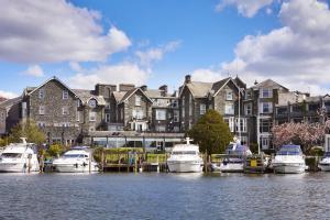 a group of boats docked in front of a large building at Macdonald Old England Hotel & Spa in Bowness-on-Windermere