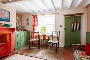 a living room with green cabinets and a table and chairs at 15 Bond Street by The Butler Collection in Arundel
