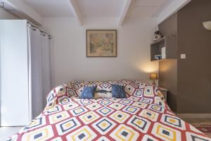 a bedroom with a bed with a colorful bedspread at Studio - les Adrets Esterel in Fréjus