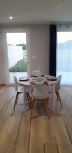 a white dining room with a table and chairs at Le Cocon de Crussol, classé 3 étoiles in Granges-lès-Valence