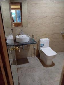 a bathroom with a sink and a toilet and a mirror at Hotel Zen in Khajurāho