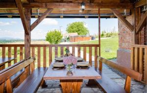 a wooden table with plates and flowers on a porch at Beautiful Home In Stubicka Slatina in Stubička Slatina
