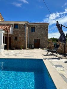 a villa with a swimming pool in front of a house at Villa Manuela in Kras