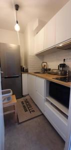 una cucina con mobili bianchi e un frigorifero nero di Studio Calme à 3min des plages à pied a Marsiglia