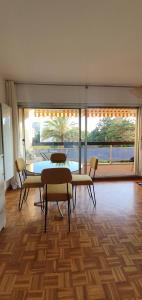 una stanza con un tavolo e sedie e una grande finestra di Studio Calme à 3min des plages à pied a Marsiglia