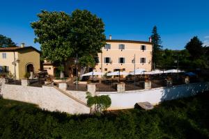 budynek ze stołami i parasolami przed nim w obiekcie AGRITURISMO Villino Bellavista w mieście Spoleto