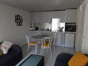 a kitchen with a table and chairs in a room at Le Val Rose 150m de la mer in Jullouville-les-Pins