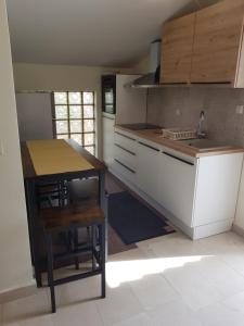 eine Küche mit einer Theke, einem Waschbecken und einem Tisch in der Unterkunft Apartmani Kornatska in Tribunj