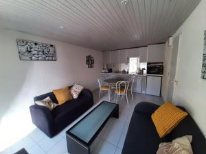 a living room with a couch and a table at Le Val Rose 150m de la mer in Jullouville-les-Pins +17 photos