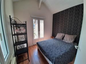 a bedroom with a bed and a black headboard at Le Val Rose 150m de la mer in Jullouville-les-Pins