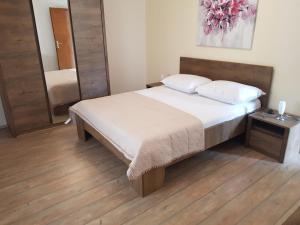 ein Schlafzimmer mit einem großen Bett und einem Spiegel in der Unterkunft Apartmani Kornatska in Tribunj
